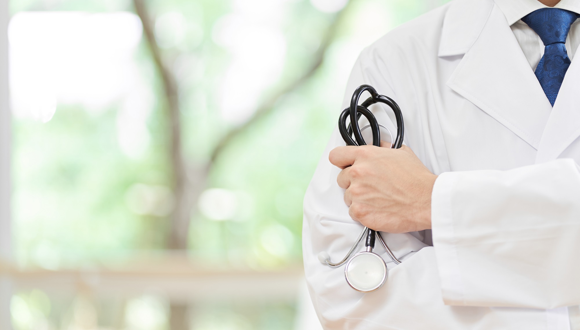 Hands of a male doctor with a stethoscope at the hospital